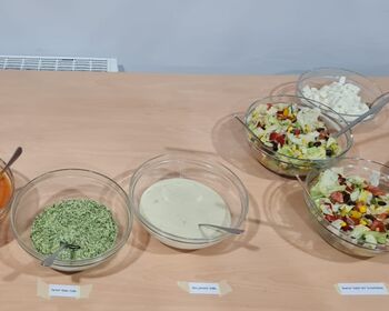 Ein Buffet mit Salaten, Soßen, Dips und Pasta.