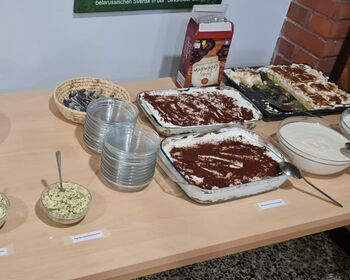 Ein Buffet mit Brötchen, Kräuterbutter und diversen Nachspeisen.